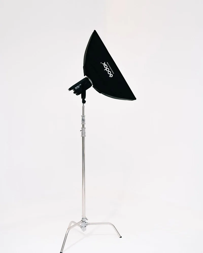 Černý softbox nasazený na ateliérovém svítidle na kovovém stativu